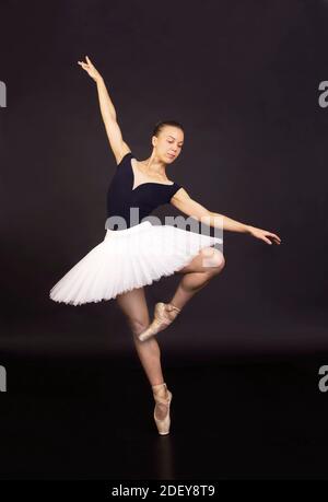 Magnifique ballerine dans un ballet blanc de tutu dansant. Studio tournant sur un fond sombre , images isolées. Banque D'Images