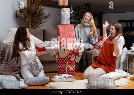 jeunes filles ayant plaisir emballer des cadeaux à la maison, grand travail d'équipe d'amis emballer des cadeaux pour noël, se préparer pour le prochain an et noël Banque D'Images