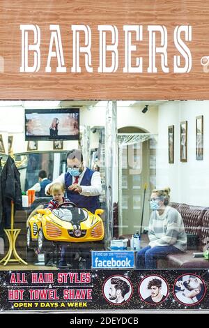 Worcester, Royaume-Uni. 2 décembre 2020. Les jeunes sont rapides aux barbiers que le verrouillage est levé pour obtenir que les cheveux avant-Noël coupés. Un jeune homme peut être vu avec une garniture dans un siège spécial de voiture de course dans un magasin de barbers dans le centre-ville de Worcester. Credit Lee Hudson/Alay Live News Banque D'Images