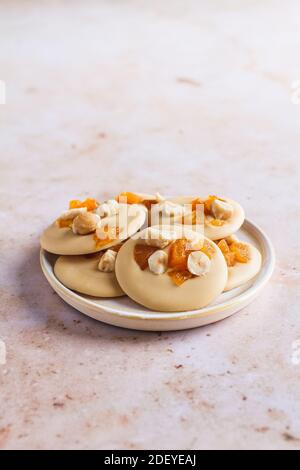 Petite assiette de mendiants au chocolat blond aux noisettes et aux abricots. Banque D'Images