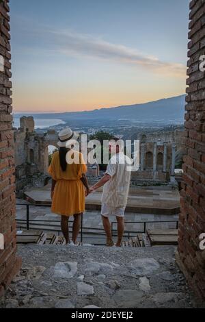 Couple hommes et femme visite les ruines du théâtre grec ancien à Taormina sur fond de volcan Etna, Italie. Taormina située dans la ville métropolitaine de Messine, sur la côte est de l'île de Sicile Italie Banque D'Images