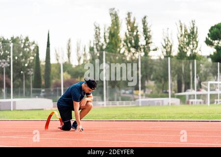 Photo de l'entraînement d'un jeune athlète avec prothèse de jambe sur piste de course à pied. Banque D'Images