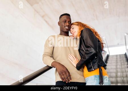 Photo d'un jeune couple multiethnique qui s'embrasse dans les escaliers. Banque D'Images