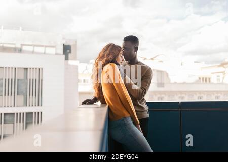 Photo de jeune couple multiethnique qui embrasse et embrasse. Banque D'Images