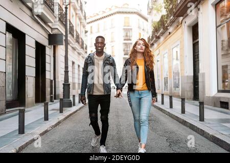 Photo de jeune couple multiethnique s'amusant dans la rue. Banque D'Images