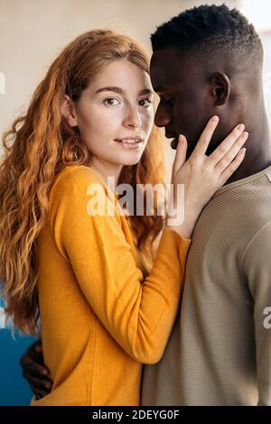 Photo de jeune couple multiethnique qui embrasse et embrasse. Banque D'Images