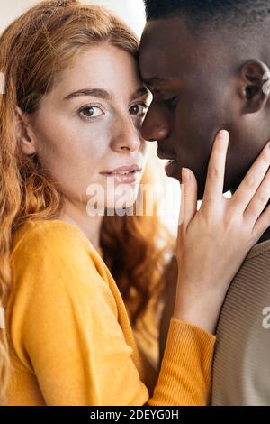 Photo de jeune couple multiethnique qui embrasse et embrasse. Banque D'Images