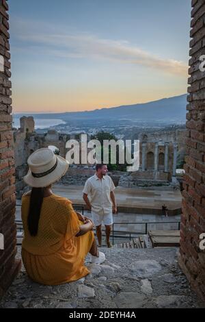 Couple hommes et femme visite les ruines du théâtre grec ancien à Taormina sur fond de volcan Etna, Italie. Taormina située dans la ville métropolitaine de Messine, sur la côte est de l'île de Sicile Italie Banque D'Images