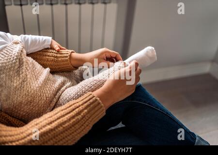 Photo de la mère non reconnue mettant des chaussettes à son bébé. Banque D'Images