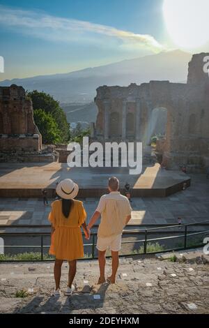 Couple hommes et femme visite les ruines du théâtre grec ancien à Taormina sur fond de volcan Etna, Italie. Taormina située dans la ville métropolitaine de Messine, sur la côte est de l'île de Sicile Italie Banque D'Images