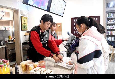 (201202) -- XI'AN, 2 décembre 2020 (Xinhua) -- les membres du personnel Li Tao et Cao Ruihua prennent des commandes pour les clients du café Silence dans le district de Xincheng de Xi'an, dans la province de Shaanxi, dans le nord-ouest de la Chine, le 1er décembre 2020. Silence Coffee, un café ouvert à Xi'an il y a plus de deux mois, est également un incubateur d'entreprises créé pour les personnes handicapées. Trois des quatre membres du personnel de Silence Coffee sont des baristas malentendants. Ils communiquent avec les clients en utilisant la langue des signes ou en tapant sur leur téléphone cellulaire. En travaillant sur deux quarts, les quatre membres ont effectué des travaux de routine dans le café, y compris le café maki Banque D'Images