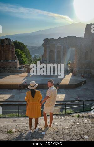 Couple hommes et femme visite les ruines du théâtre grec ancien à Taormina sur fond de volcan Etna, Italie. Taormina située dans la ville métropolitaine de Messine, sur la côte est de l'île de Sicile Italie Banque D'Images