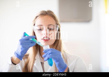 un jeune étudiant apprend un essai scientifique dans un laboratoire Banque D'Images