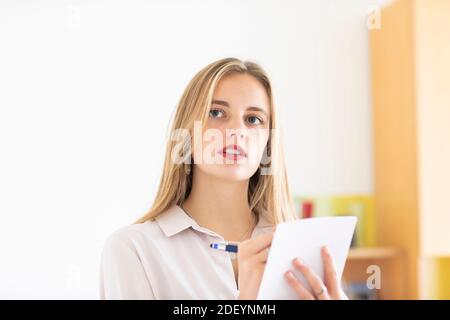 jeune femme avec un crayon et un folio dans un bureau travaillant Banque D'Images