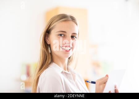 jeune femme avec un crayon et un folio dans un bureau travaillant Banque D'Images