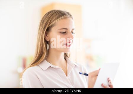 jeune femme avec un crayon et un folio dans un bureau travaillant Banque D'Images