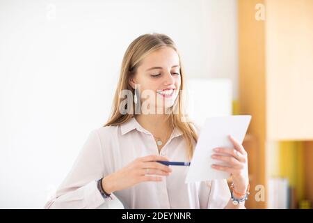 jeune femme avec un crayon et un folio dans un bureau travaillant Banque D'Images