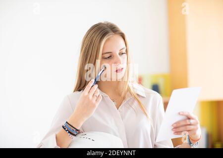 jeune femme avec un crayon et un folio dans un bureau travaillant Banque D'Images