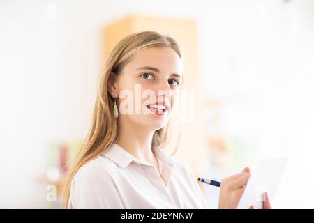 jeune femme avec un crayon et un folio dans un bureau travaillant Banque D'Images