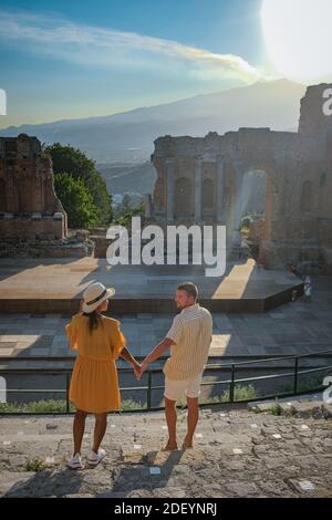 Couple hommes et femme visite les ruines du théâtre grec ancien à Taormina sur fond de volcan Etna, Italie. Taormina située dans la ville métropolitaine de Messine, sur la côte est de l'île de Sicile Italie Banque D'Images