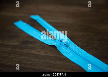 Fermeture éclair bleue sur fond de bois sombre Banque D'Images