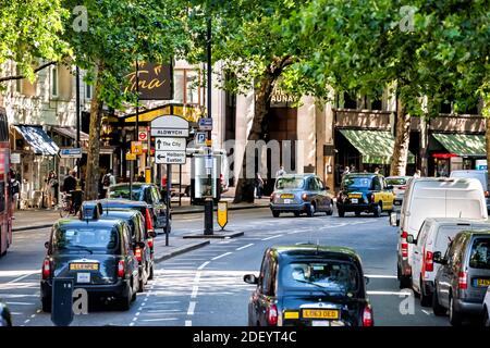 Londres, Royaume-Uni - 22 juin 2018 : vue à grand angle sur la rue avec arbres verts en ville avec taxis sur la rue Aldwych dans le centre-ville et panneaux Banque D'Images