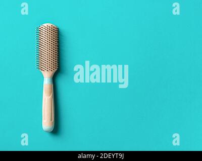 Nouvelle brosse à cheveux beige avec poignée sur fond bleu marin texturé. Peignage et soins des cheveux, outils de coiffure, articles de mercerie. Studio shot espace de la copie Banque D'Images