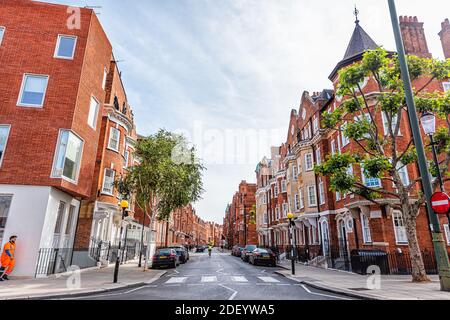 Londres, Royaume-Uni - 24 juin 2018 : rue dans West Chelsea et quartier de Kensington avec terrasse en brique rouge jaune, maison de ville en terrasse, voitures garées par r Banque D'Images