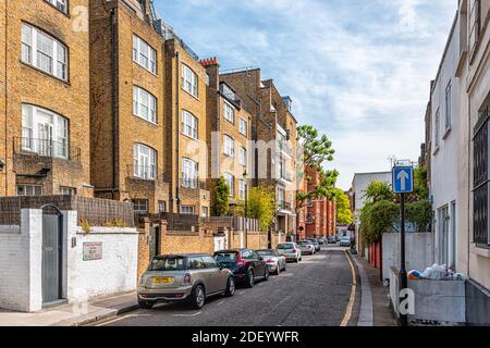 Londres, Royaume-Uni - 24 juin 2018 : rue Bray place dans le quartier de West Chelsea et Kensington avec terrasse en briques rouges jaunes, maisons en rangée, voitures Banque D'Images