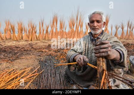 Srinagar, Inde. 02e décembre 2020. Un cachemiri prépare des brindilles pour faire 'Kangriss', (pots de feu traditionnels) dans le village de Shallabugh du district de Ganderbal à environ 22kms de Srinagar, La capitale estivale de Jammu-et-Cachemire.le Kangri est un pot-de-feu traditionnel qui maintient les gens au chaud pendant les mois d'hiver rigoureux quand la température descend à moins 20. Kangri est fait d'argile et de brindilles dans lesquels le charbon de bois chaud est conservé. Crédit : SOPA Images Limited/Alamy Live News Banque D'Images