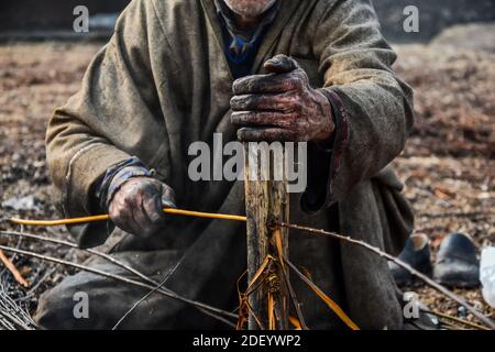 Srinagar, Inde. 02e décembre 2020. Un cachemiri prépare des brindilles pour faire 'Kangriss', (pots de feu traditionnels) dans le village de Shallabugh du district de Ganderbal à environ 22kms de Srinagar, La capitale estivale de Jammu-et-Cachemire.le Kangri est un pot-de-feu traditionnel qui maintient les gens au chaud pendant les mois d'hiver rigoureux quand la température descend à moins 20. Kangri est fait d'argile et de brindilles dans lesquels le charbon de bois chaud est conservé. Crédit : SOPA Images Limited/Alamy Live News Banque D'Images