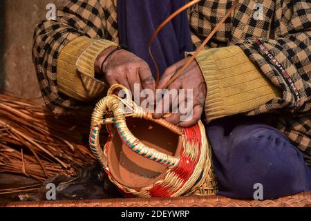 Srinagar, Inde. 02e décembre 2020. Un cachemiri fait un 'Kangri', un pot de feu traditionnel dans son atelier à la périphérie de Srinagar, la capitale estivale de Jammu-et-Cachemire.le kangri est un pot de feu traditionnel qui maintient les gens au chaud pendant les mois d'hiver rigoureux quand la température descend à moins 20. Kangri est fait d'argile et de brindilles dans lesquels le charbon de bois chaud est conservé. Crédit : SOPA Images Limited/Alamy Live News Banque D'Images