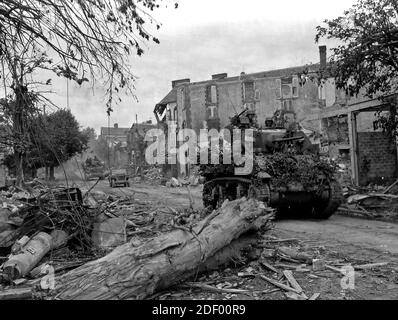 Les chars américains passent par une rue naufragé à Coutances, en Normandie, dans leur route vers la mer au-delà de la ville. Coutances, capturé par les troupes américaines le 29 juillet 1944, est à environ 18 milles à l'ouest de Saint-Lo et a été la clé des routes d'évacuation pour des milliers de soldats allemands hemed plus au nord Banque D'Images