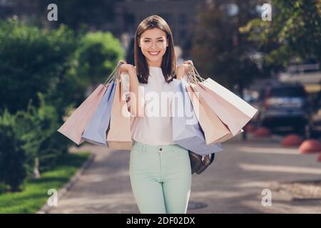 Photo portrait de fille excitée portant de nombreux sacs de shopping à l'extérieur Banque D'Images