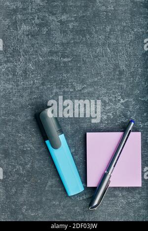 Le stylo et un marqueur bleu se trouvent sur un arrière-plan gris Banque D'Images