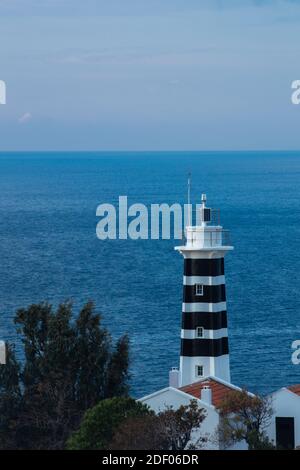 Un phare vertical noir et blanc sur fond de une mer sans limites Banque D'Images
