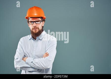 Homme en orange casque chemise court vue sur fond bleu travaux de construction Banque D'Images