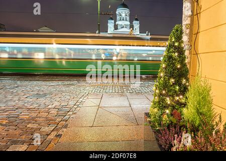 Helsinki, Finlande 30 novembre 2020 Centre-ville, bâtiments historiques et passage en tramway vert. Lanternes brûlantes et réflexions après la pluie. Photo de haute qualité Banque D'Images