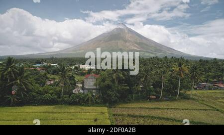 Ville rurale tropique à l'antenne des palmiers. Campagne du volcan Mayon avec chalets, lodges et champs au bord du lac. Cinematic Philippines vert tropical terres agricoles à personne nature paysage tir de drone Banque D'Images