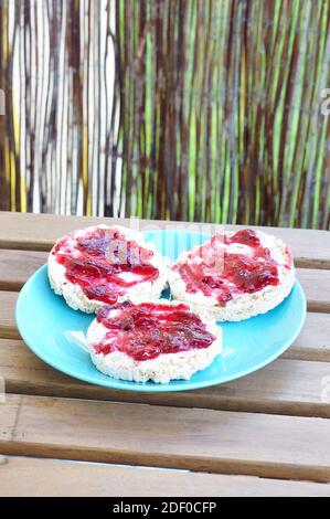 Un gros plan de trois délicieux craquelins de riz au cassis marmelade sur plaque bleue Banque D'Images