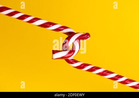 Sucettes de canne à sucre sur fond jaune, bonbons de Noël. Banque D'Images