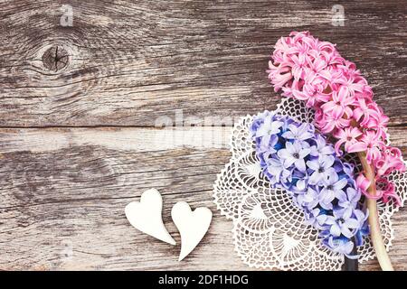 Deux coeurs décoratifs et jacinthe fraîche sur fond de bois vieilli. Image tonifiée, concept de la Saint-Valentin. Banque D'Images