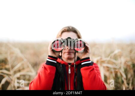 femme tenant des jumelles à la ferme Banque D'Images