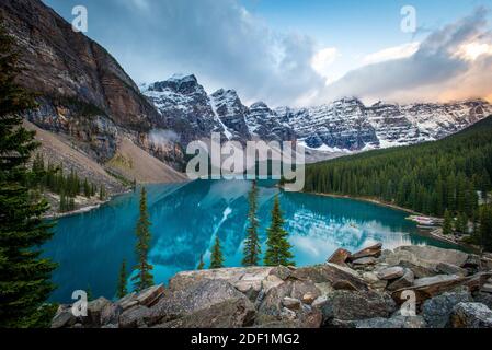 Les canoteurs pagayez sur un canoë au lever du soleil sur le lac Moraine à l' Parc national Banff Banque D'Images