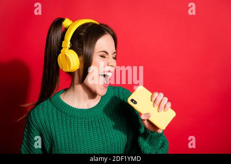 Le chanteur excité avec un microphone sur fond rouge. L'homme