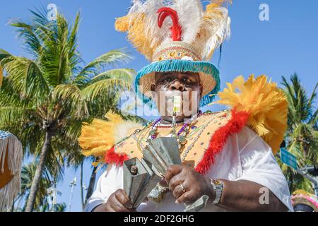 Miami Beach Florida,South Beach,Ocean Drive,Black African Caribbean man,Junkanoo bande cloche cow-bell sifflet joueur musicien jouant Banque D'Images