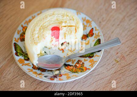 Une belle photo d'un dessert sur une assiette blanche avec des papillons colorés Banque D'Images