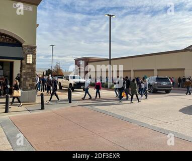 Allen, TX / USA - 27 novembre 2020: Une vue des personnes portant le masque et portant les sacs de shopping marchant dans les magasins d'usine Allen Premium Outlets sur Black FR Banque D'Images