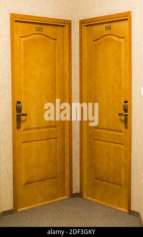 Une photo verticale de portes en bois dans un hôtel au bout d'un hall Banque D'Images