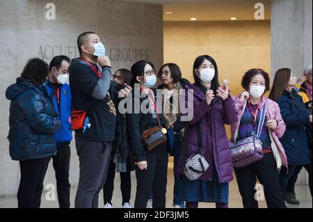 Les touristes portent des masques médicaux au Louvre par mesure de précaution contre le coronavirus à Paris, France, le 4 mars 2020. Le musée du Louvre a rouvert ses portes mercredi après que la direction ait pris des mesures pour apaiser les craintes du personnel au sujet de la propagation du coronavirus, qui avait déclenché un arrêt de travail de deux jours. Dans une déclaration, le musée le plus visité au monde a déclaré que, face aux « préoccupations légitimes » du personnel sur la COVID-19, il avait accepté de prendre des « mesures supplémentaires » pour assurer la sécurité des employés et des visiteurs. Photo de Magali Cohen/ABACAPRESS.COM Banque D'Images